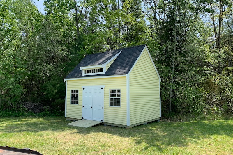 beyond storage - alternate uses for backyard sheds - beautiful yellow and white shed with black roofing, windows, loft, and double-doors for easy access