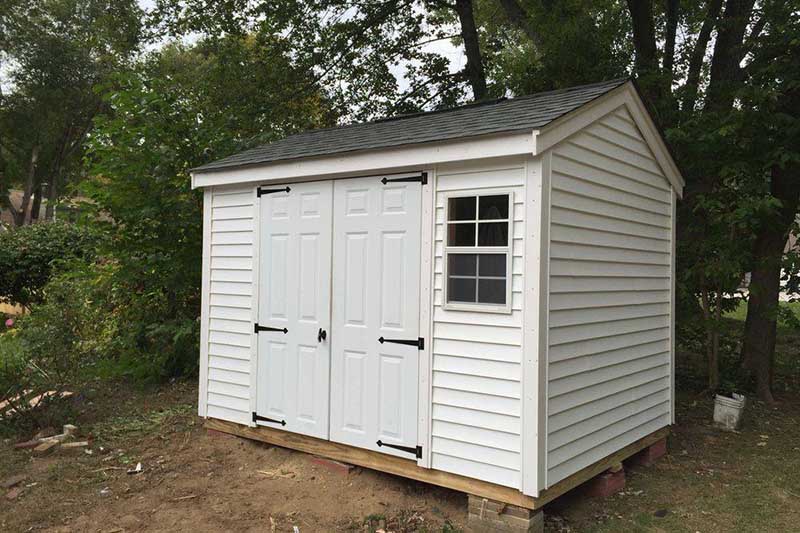 hassle free delivery and installation - white shed with double doors and a window during installation at a customer's property