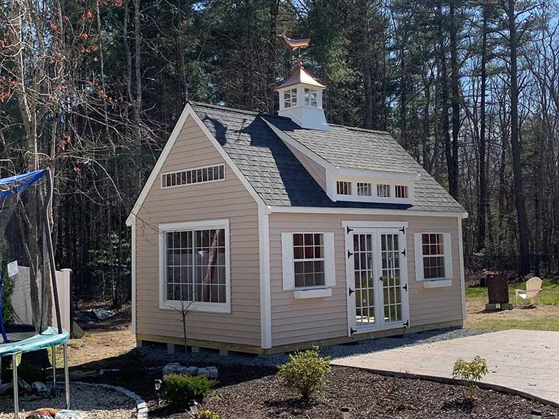 large backyard shed with lots of windows and custom trim